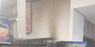 Um bandido incendeia uma máquina de supermercado usando uma garrafa de gasolina