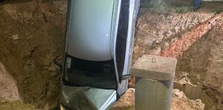 Mulher perde controle de carro e cai em buraco de obras do BRT na Avenida do CPA
